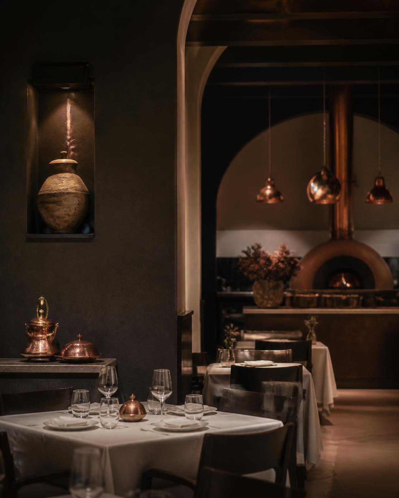 Refined Turkish restaurant interior with warm lighting, copper details and dressed tables